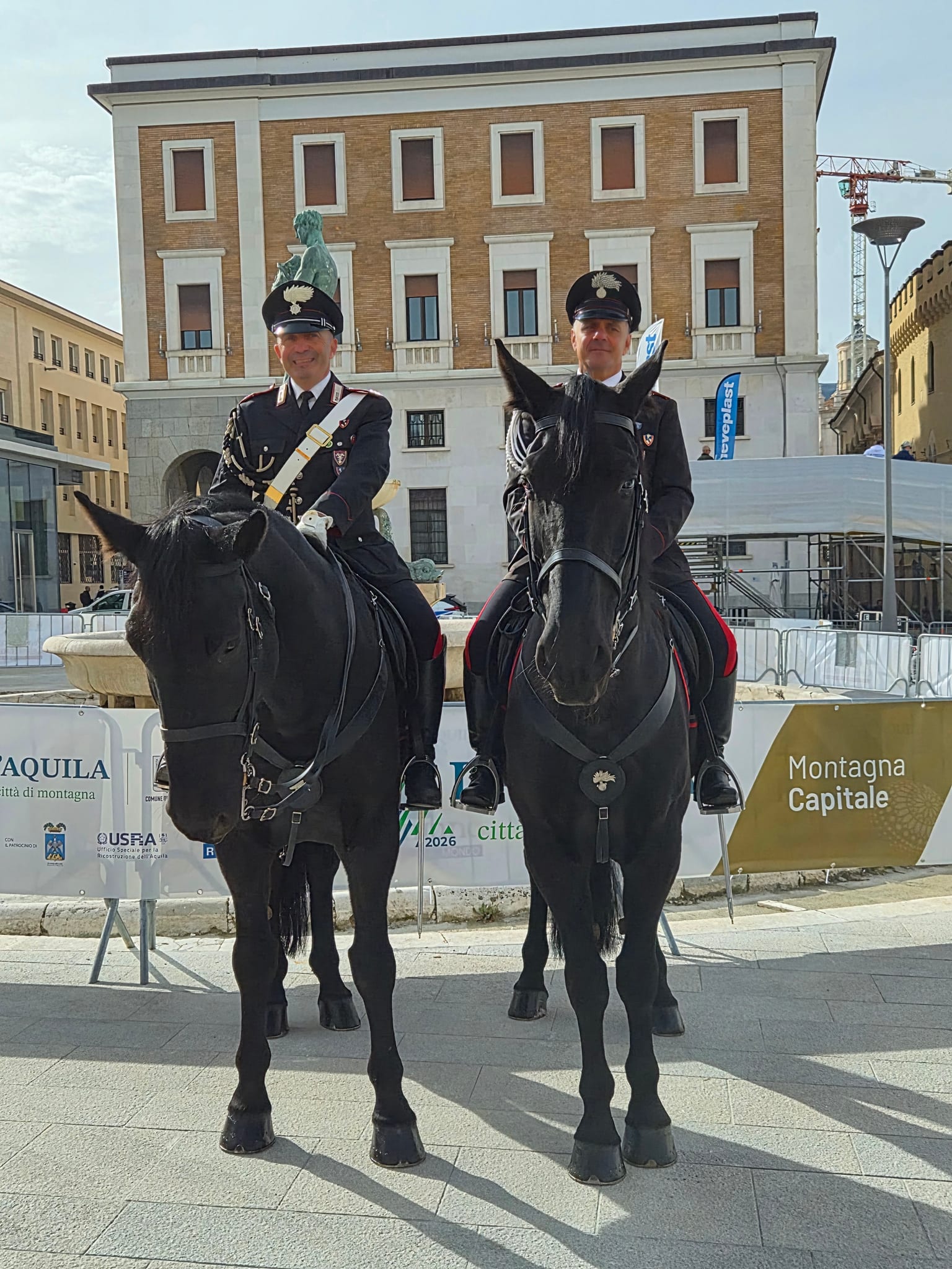 Due carabinieri in uniforme a cavallo davanti agli allestimenti della manifestazione in Piazza Duomo