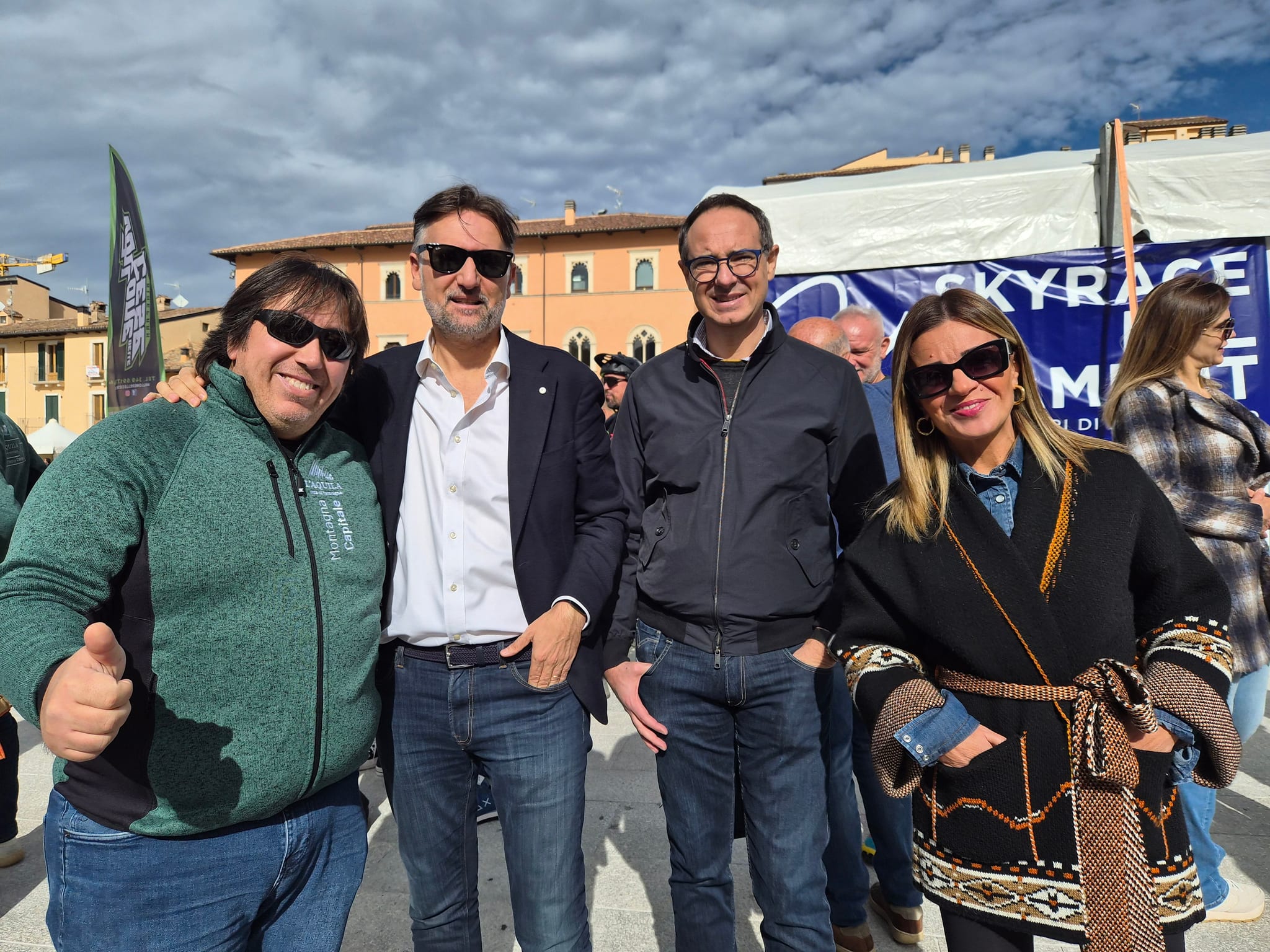 Quattro persone in posa in Piazza Duomo davanti agli allestimenti del Villaggio